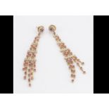 A pair of contemporary continental yellow metal diamond and pink sapphire chain drop earrings, of