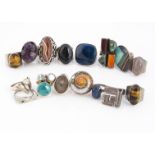 A collection of white metal rings, set with gems and enamel, including amethyst, blue jasper,