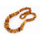 A large graduated rough knotted amber necklace, various shapes, some opaque others translucent, 38