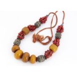 A Moroccan pressed amber, white metal, coral and enamel necklace, in the Berber style, 52 cm 250g