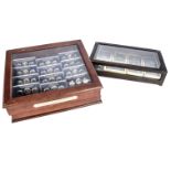 Two presentation cases with US coins and medallions, one wooden and glazed case marked The US