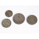 A set of four Middle Eastern white metal coins, having the emblem of Persia and graduating in