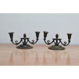 A pair of art deco bronze Danish two branch candelabra's, in the style of Just Anderson, the paint