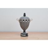 A 20th century Wedgwood black and white Jasperware urn, striped design, with Bacchus handles, the