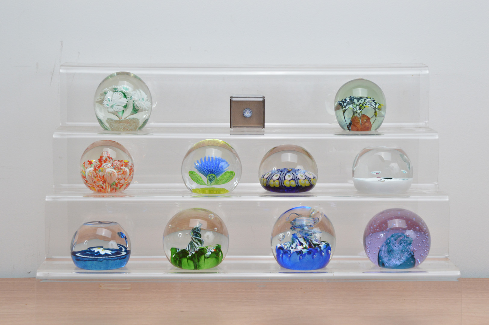 A collection of paperweights, of varying designs and styles, including seven Caithness examples,