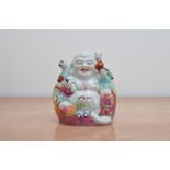 An early to mid 20th century ceramic Chinese Buddha, with five climbing children, marks to the base,