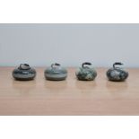 Four mid 20th century paperweights, in the form of curling stones, two marble examples, 7.5cm to 6.