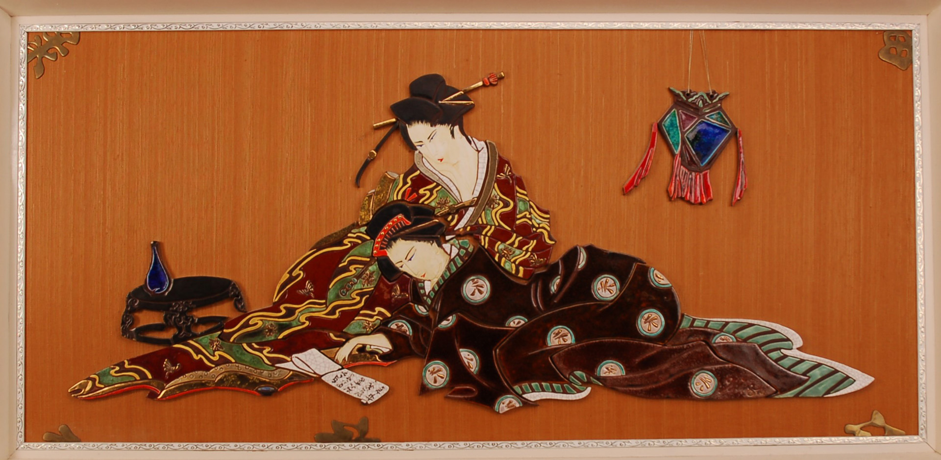 A large Japanese tile picture, on a wooden background, featuring two reclining women in