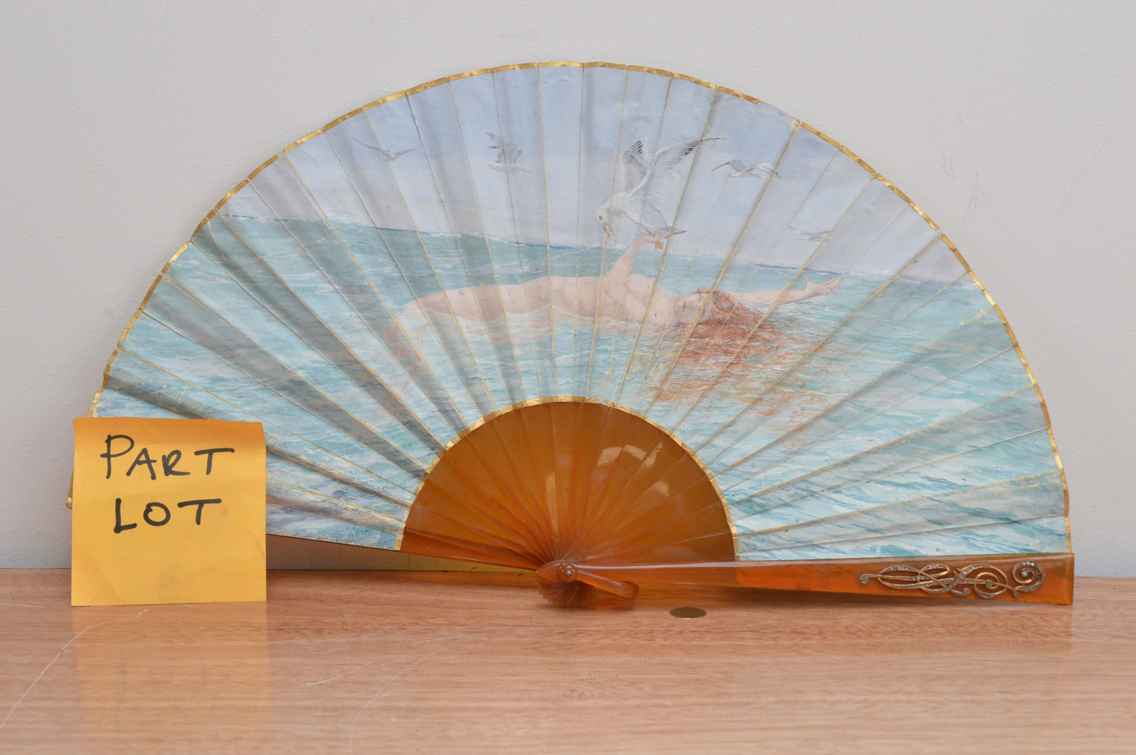 Three early 20th century fans, comprising an art deco example, with gold decoration and hand painted