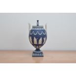 A 20th century Wedgwood Jasperware twin handled lidded 'Sacrifice' urn, Portland blue, impressed