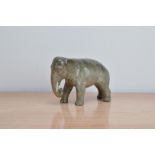 An early 20th century porcelain elephant figurine, 13cm H x 20cm W, AF