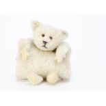 An American muff teddy bear 1920s, with white mohair, orange and black glass eyes, inset black cloth