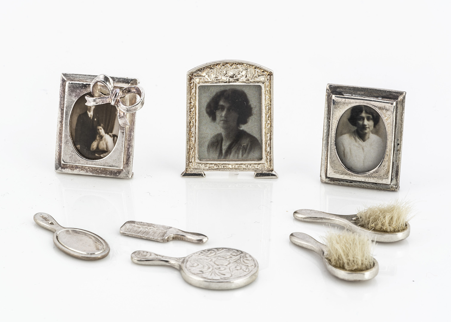 A modern dolls' house hallmarked silver photo frame by Vic Pain, with bow decoration --½in. (1.5cm.)