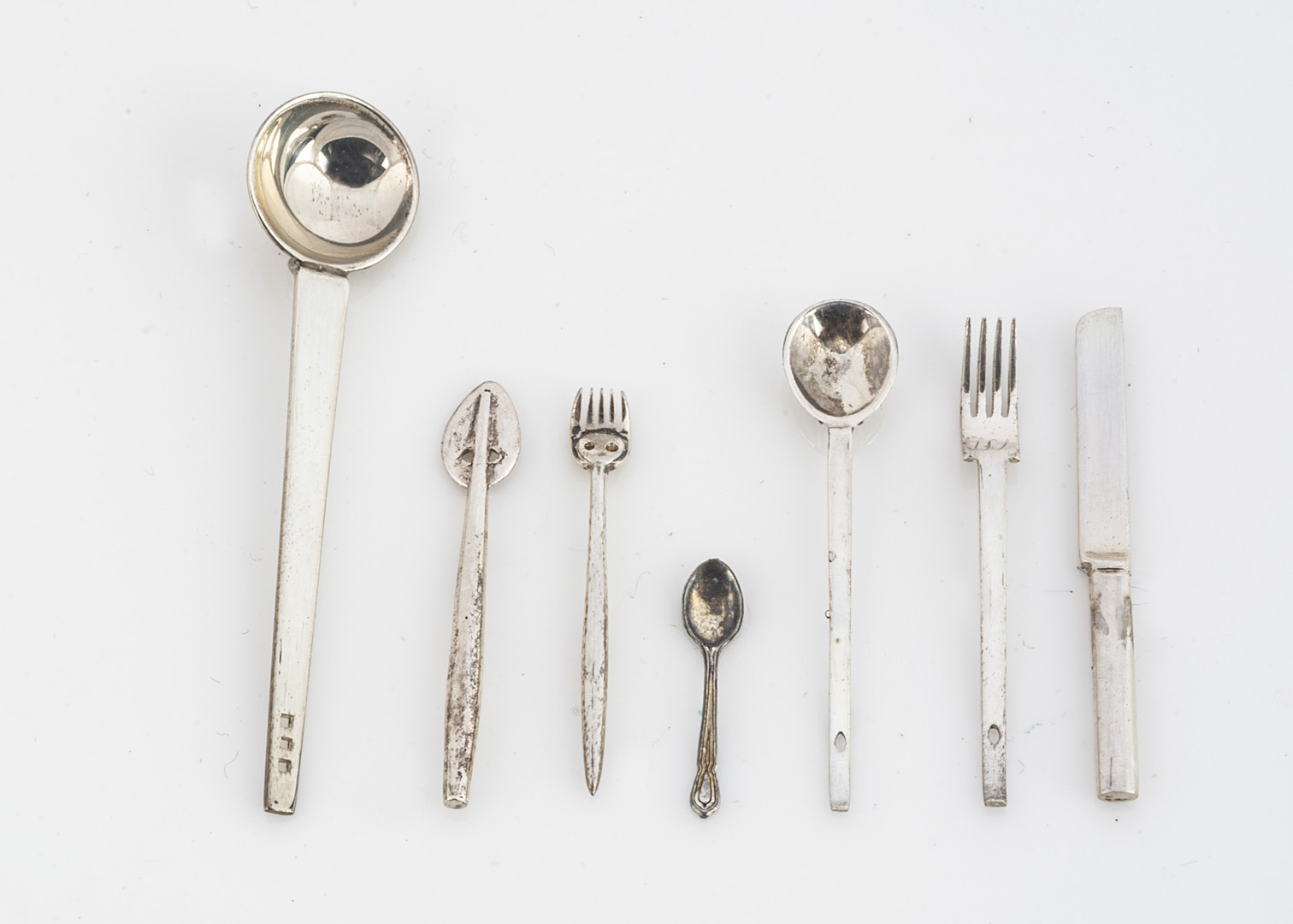 Modern dolls' house white metal cutlery, comprising a set of eight knives, eight forks, eight