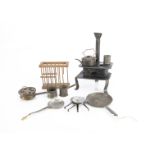 An early tinplate dolls’ house stove, black painted with two rings, oven and chimney —6in. (15cm.)