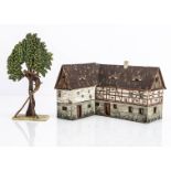 A Heinrichsen Figuren unusual painted wooden model house, L shaped house with lean-to on back with