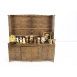 A lithographed tinplate doll's dresser, probably a produce tin of maple wood and opening cupboard
