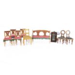 Dolls’ house furniture, a sofa —4in. (10cm.) wide and four wooden chairs with pink upholstery and