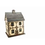 A 1930s home-built dolls’ house, cream and grained painted wooden timbered façade with dummy central