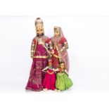 A very large carved wooden headed Rajasthani couple, in elaborate costumes with wooden frame lower