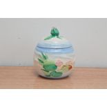 A Clarice Cliff ceramic Preserve jar with cover, floral design with a flower finial, 11cm H marked