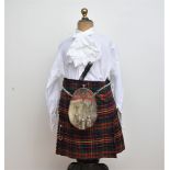 A collection of children's highland clothing, comprising three kilts of differing sizes, two