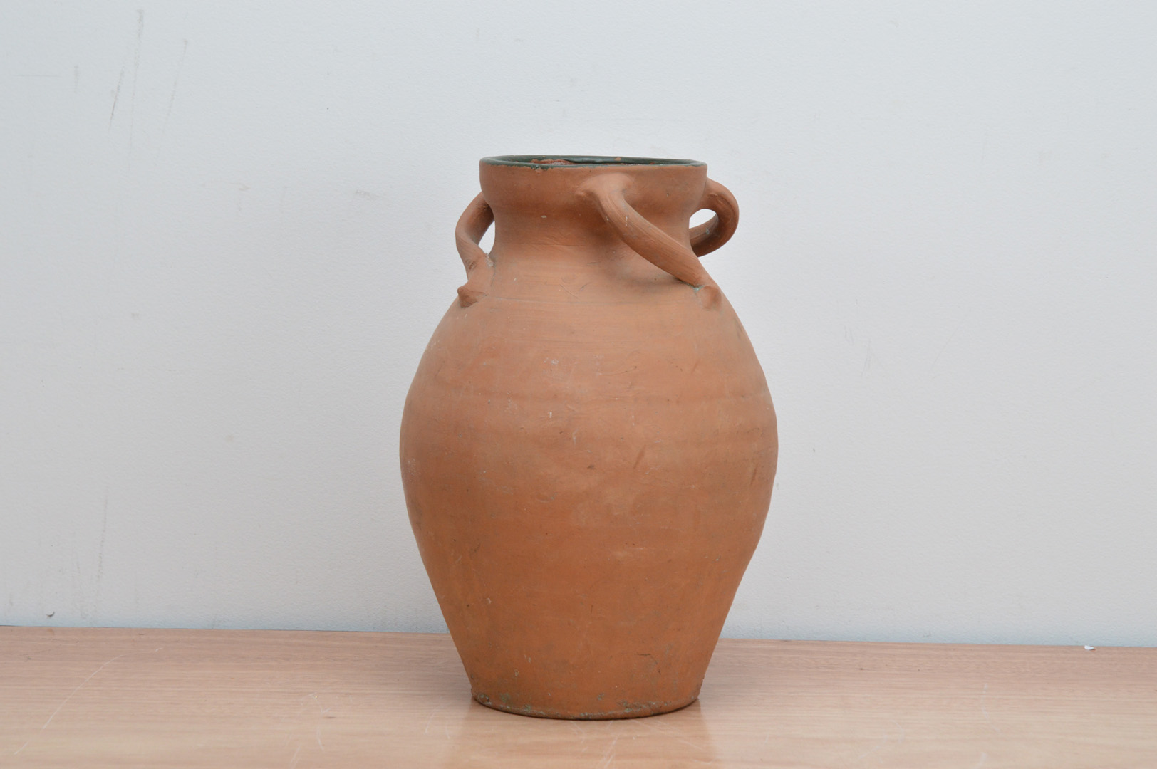 A 20th century terracotta vase, with three spiral handles, internally glazed, the rim painted in