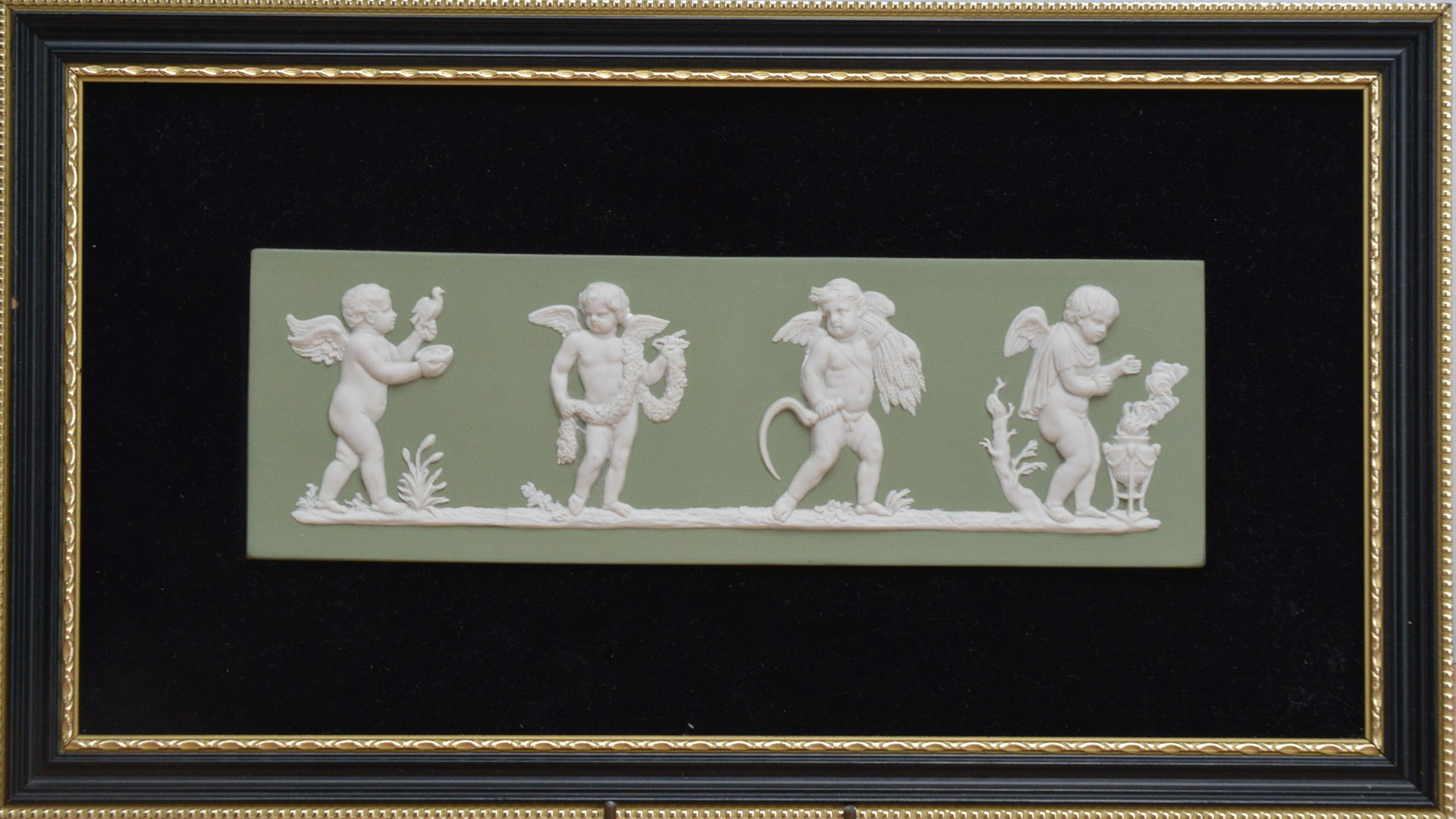 A 1970's Wedgwood Jasperware plaque titled 'The Seasons', green design depicting four cherubs,