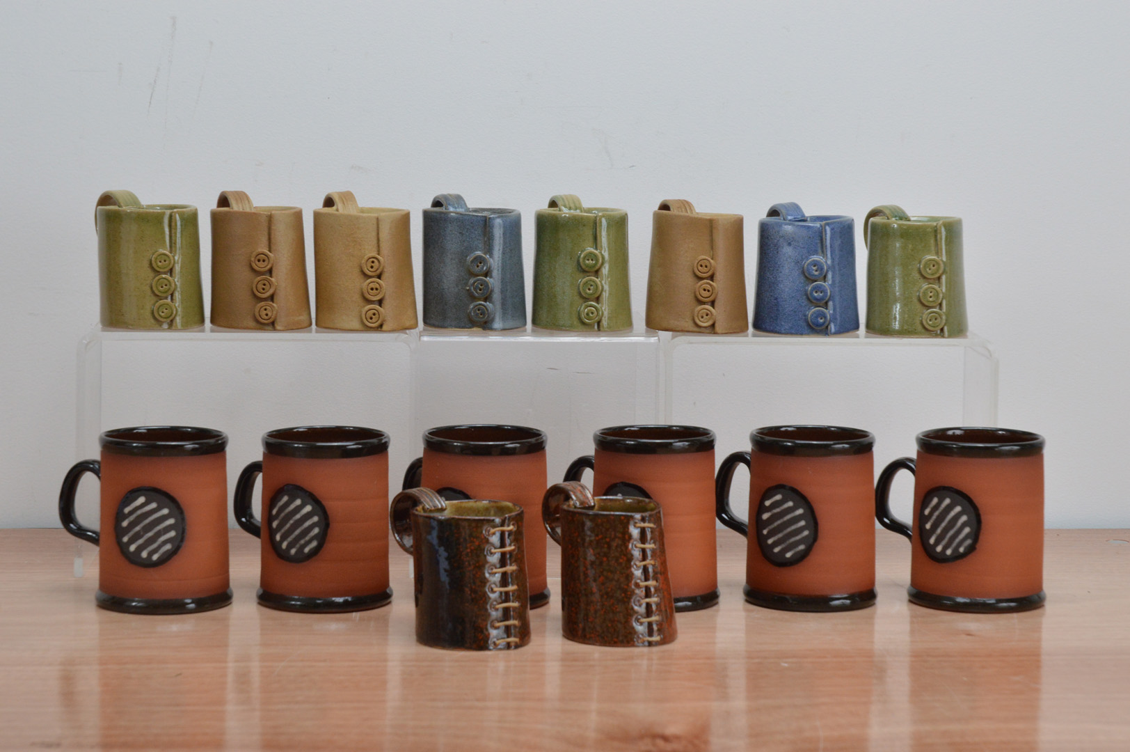 Six partially glazed studio pottery terracotta mugs stamped Baxter, 10cm high, together with eight