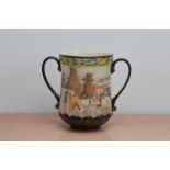 A Royal Doulton ceramic twin handled love cup, titled Pottery in the past 16cm high