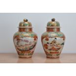 A pair of late 19th century Japanese ceramic baluster vases with covers, both with red and gilt