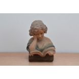 An early 20th century continental bisque figurine, depicting a girl reading a book, some damage