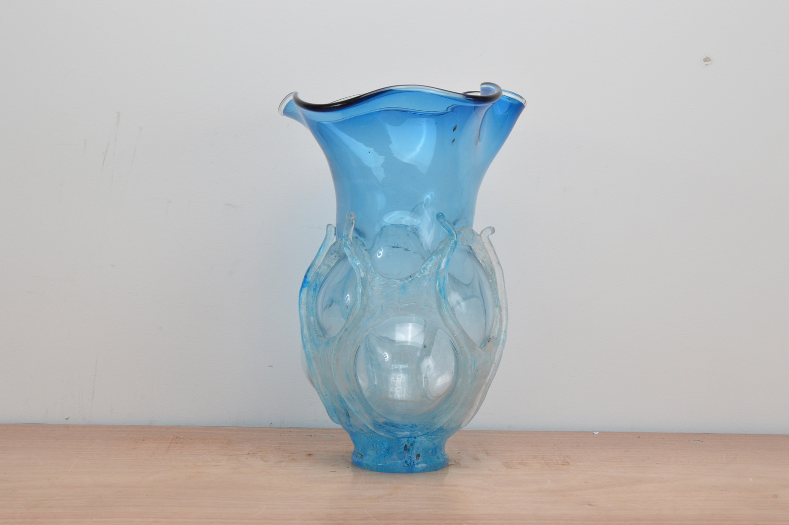 A large blue studio glass vase, globular body, with crimped rim, raised frosted decoration of