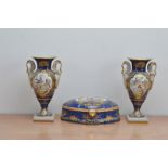 A pair of 20th century French ceramic twin handled urns, together with a lidded box in oval shape,