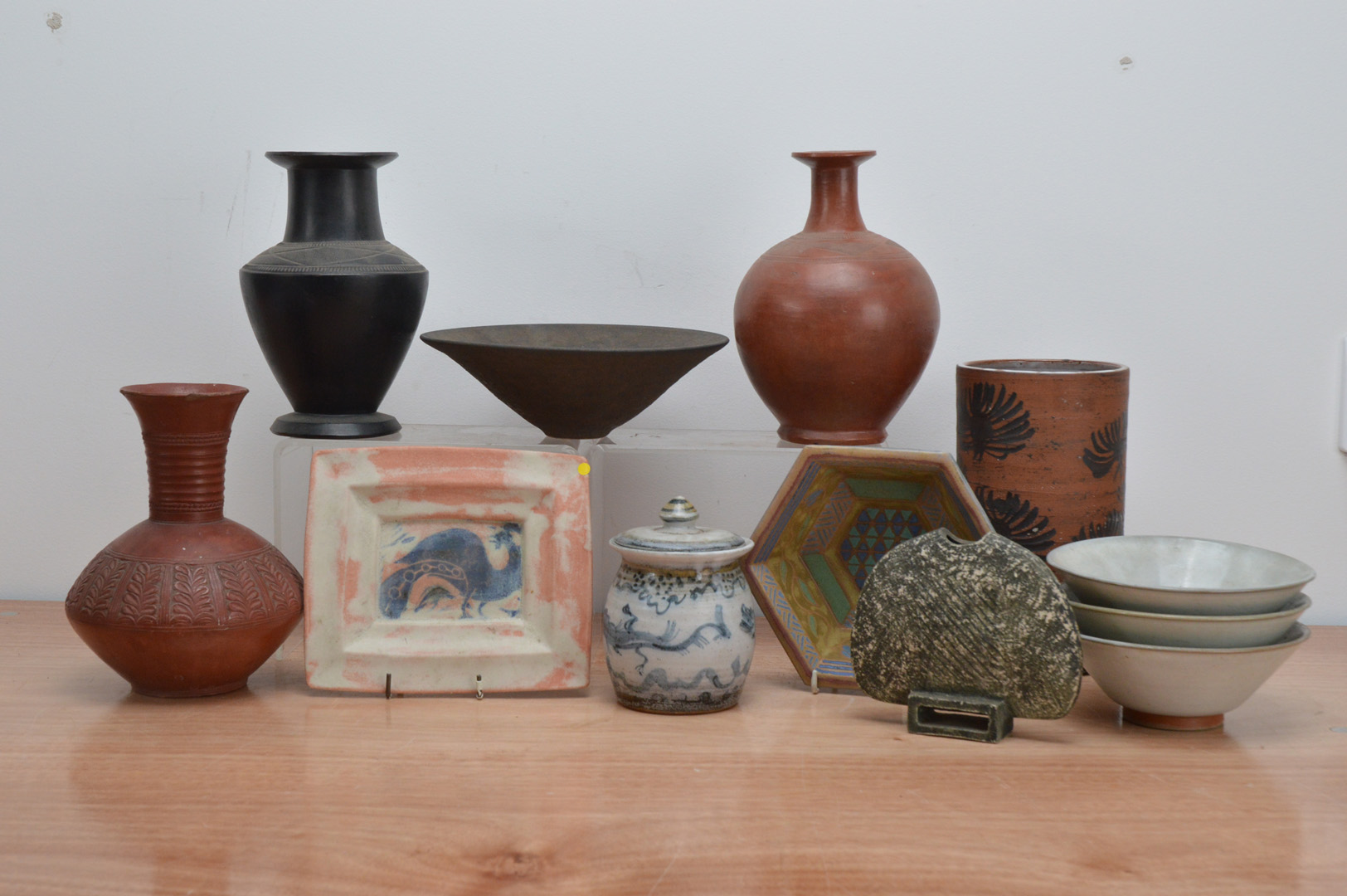 A collection of studio pottery, comprising a small rectangular stoneware plate with central cockerel