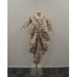 A collection of early 20th century clothing, comprising a floral dress, white jacket and trousers