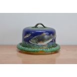 A studio pottery cheese dish and cover, with fish design, the cover with a handle in the form of a