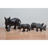 Three Rhino sculptures, comprising a painted cast metal example 27cm long, and two ebonised examples