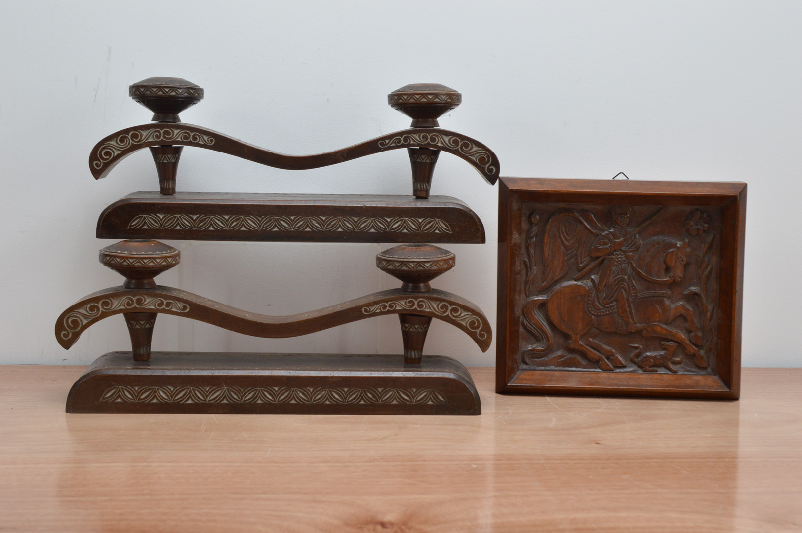 A pair of carved eastern European wooden candle holders, both 38.5cm W, together with a wooden