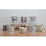 A collection of ceramic transfer tankards, including twin handled examples, three modern Wade