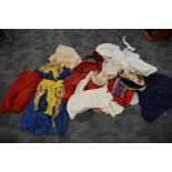 A large collection of antique clothing, including dresses, a child's fencing top, bonnets, shawls, a