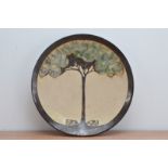 A Studio pottery terracotta wall charger by L. Stockley, glazed interior depicting a tree with two