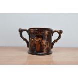 A 19th century ceramic treacle glazed 'Frog' twin handled tankard, depicting figures and dogs,