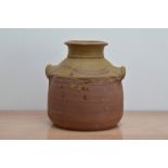 A large twin handled studio pottery terracotta pot, partial glaze, with partial makers mark