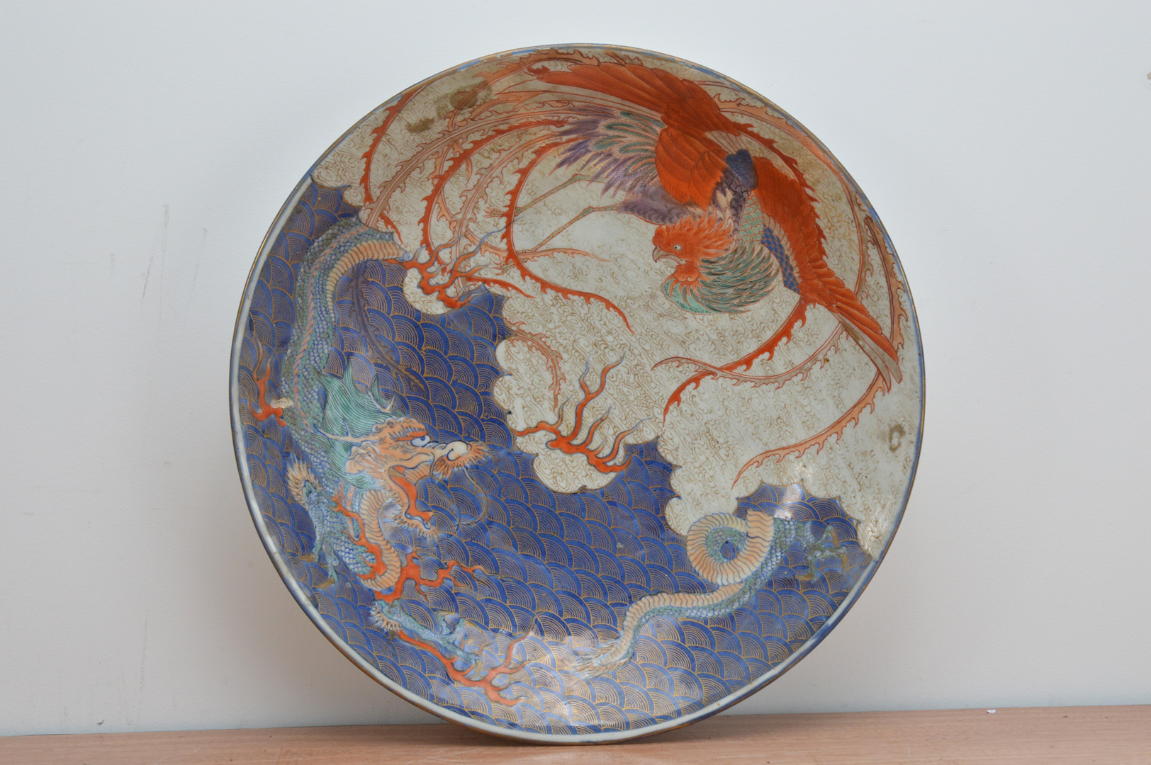 A large early 20th century Chinese porcelain charger, depicting a mythical creature and a bird, four