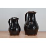 Two Tenmoku glazed stoneware jugs, of differing sizes, both with partial marks beneath the