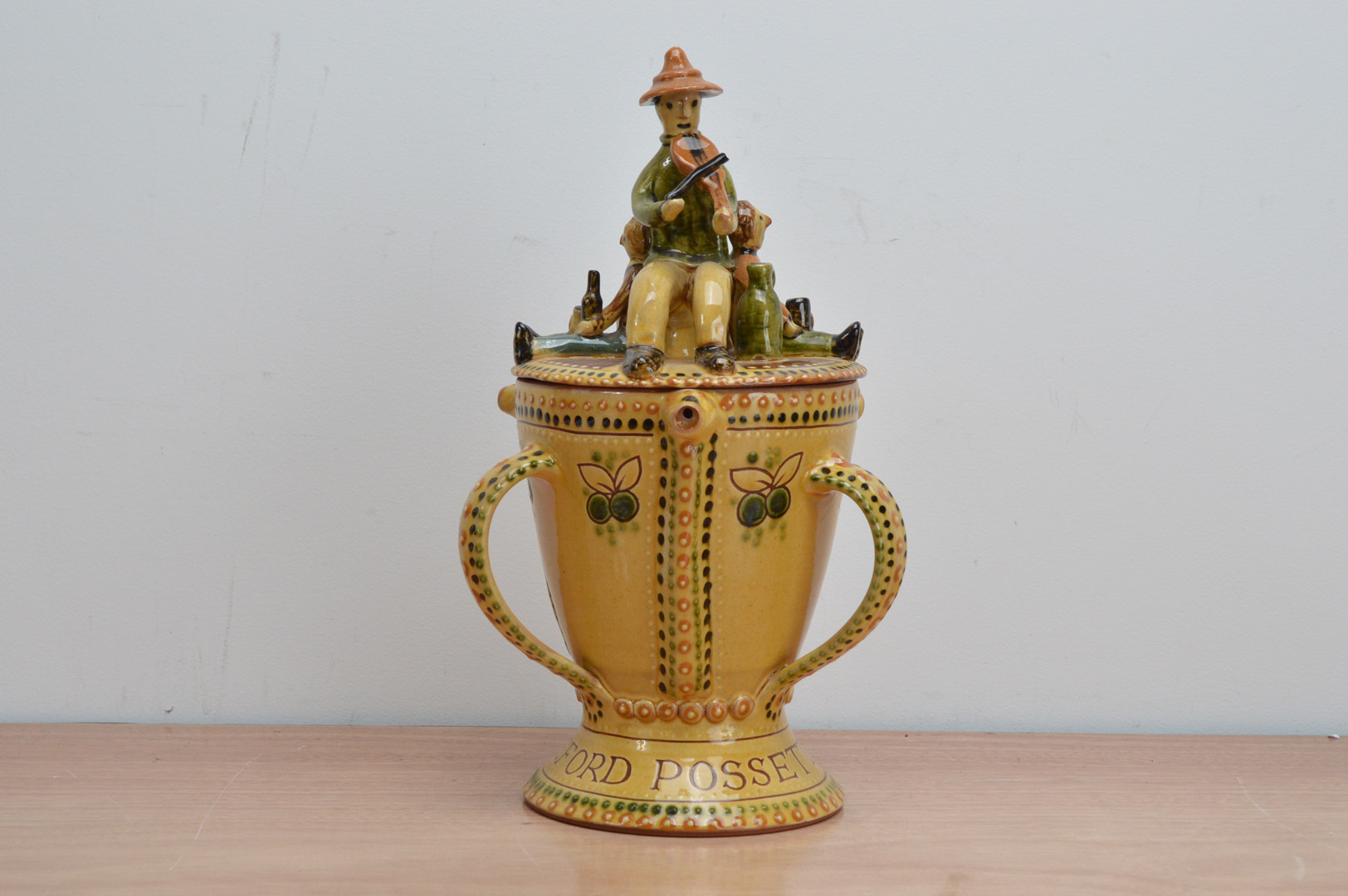 A glazed terracotta covered 'Bideford Possett Pot', by Harry Juniper, dated 1981, pedestal form with