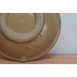 A small brown glazed stoneware studio pottery bowl, with impressed marks to the underside for