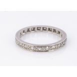 A white metal full eternity diamond set ring, the eight cut diamonds in a channel setting, ring size