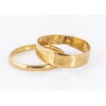 Two 22ct yellow gold wedding bands, one flattened form 5.3mm and very thin size S, together with a D
